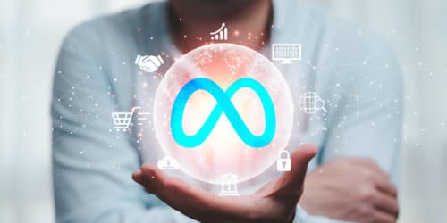 extreme close up of a man in a light blue shirt holding a floating white orb with the META logo in the center